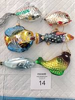 All six fish ornaments displayed on white quilted surface