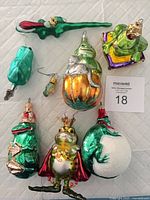 Full lot showing eight frog and lizard ornaments arranged on surface