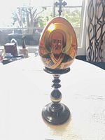 Front view of hand-painted egg on stand showing saint image
