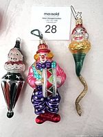 Front view of three hand-blown glass clown ornaments