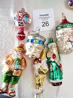 Group shot of six blown glass Santa ornaments on table