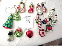 All 15 glass ornaments laid out beside MaxSold lot card