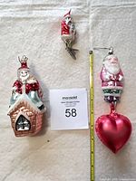 Group shot of all three glass Santa ornaments with measuring tape