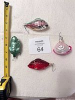 Group shot showing all four ornaments with tape measure for scale