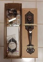 Box interiors showing unused lockset components and ornate brushed copper handle