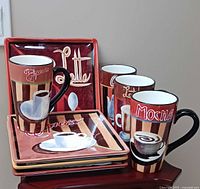 Stacked mugs and plates showing coffee graphics