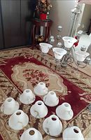 Chandelier frame laid on rug with detached glass shades visible