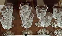 Group of ten stemmed cut-crystal glasses showing pattern details
