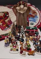 Group shot showing village figurines, angel figurine and background wall hanging