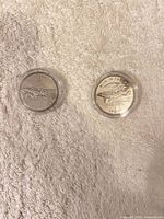 Both coins in capsules front view