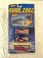 Front view of sealed Hot Wheels Guide 2002 package showing booklet and three cars