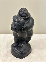 Front view of Inuit figure sculpture holding fish
