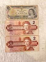 Front of three Canadian banknotes showing denominations and portraits