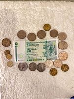 Full view of ten-dollar note surrounded by 21 coins