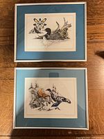 Both framed Michael Duncan prints side by side