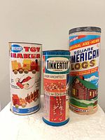 Three cylindrical building toy canisters: Tinkertoy Toy Maker, Tinkertoy Junior Architect, Square American Logs
