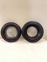 Both rubber tire ashtrays side by side, showing one with and one without glass insert