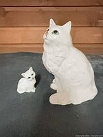 Large and small white cat figurines front view