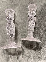 Both crystal candlestick holders upright on fabric background