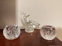Front view of two crystal candle holders and glass fish figurine