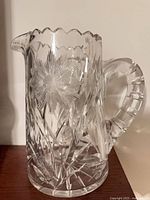 Full view of crystal pitcher showing handle, cuts, scalloped rim