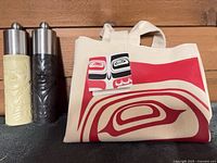 Salt and pepper mills beside canvas tote bag