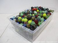 Top view of clear bin filled with large multicolor glass marbles