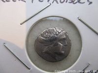 Obverse of silver coin in cardboard holder