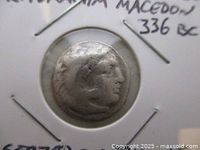 Obverse of silver coin in flip showing head of Heracles