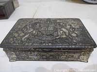 Top view of hinged silver-plated trinket box showing Dominion of Canada coat of arms and side relief
