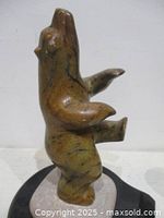 Front view of stone dancing bear on base