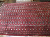 Full view of red Bokhara rug showing overall pattern and borders