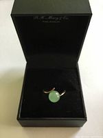 Ring in jewellery box showing jadeite sphere on gold band