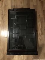 Front view of rosewood curio cabinet with glass door