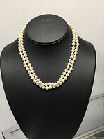 Full view of double-strand pearl necklace displayed on bust
