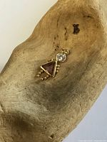 Front view of 10 kt gold little girl charm with purple triangular stone and clear round stone