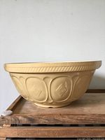 Exterior side view of yellow T.G. Green Gripstand bowl showing embossed pattern and footed base