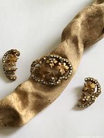 Brooch and both earrings front view on driftwood prop