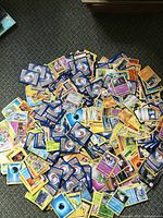 Large spread of Pokémon cards on carpet showing fronts and backs