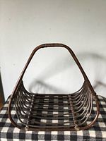 Front view of large rattan basket showing handle and open slat construction