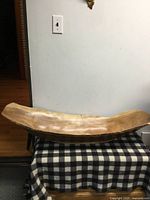 Full view of wooden trough bowl on plaid surface