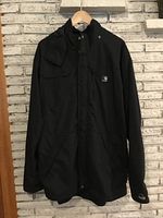 Front view of black Carhartt rain jacket hanging