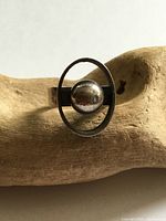 Front view showing oval frame and central sphere design