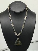 Full necklace displayed on bust showing pendant and bead arrangement