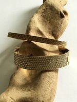 Both bangles draped on wood showing crystal pavé surfaces