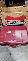 Exterior of burgundy suitcase in front of American Tourister box