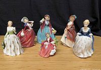 Group shot of six Royal Doulton lady figurines on table