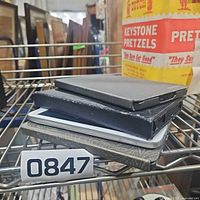 Stack of four tablets/e-readers on shelf with lot tag