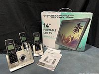 Boxed Trexonic 14" portable LED TV, three VTech cordless handsets, answering base, two charging cradles, user manuals