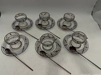 Top view of six glass cups on saucers with spoons